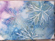 Cyanotype printed collection of mosses and seaweed on a background with blue, purple, and white colors.