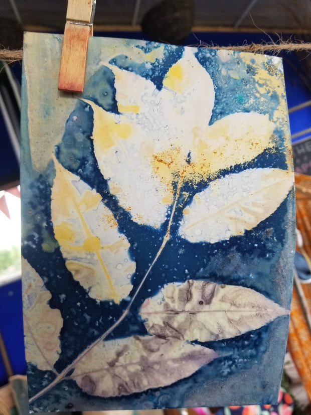 Artistic depiction of leaves on a blue background with a paintbrush