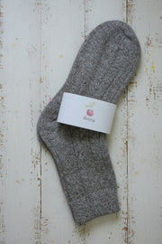 Gray sock with a white label on a wooden surface