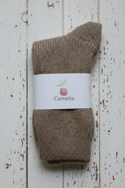 Brown sock with a 'Camelia' label on a wooden surface