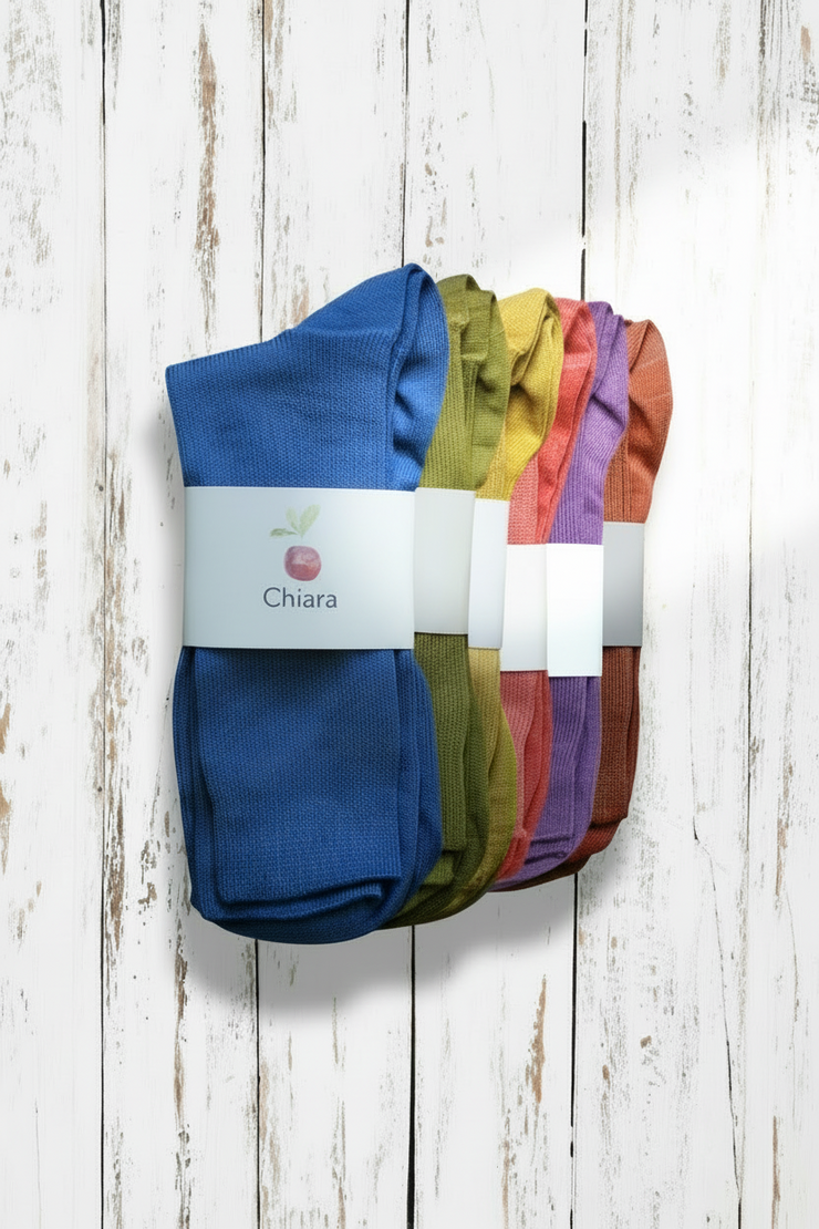 Set of colorful socks with a 'Chiara' label on a wooden surface