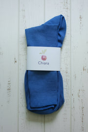 Pair of blue socks with a white label on a wooden surface