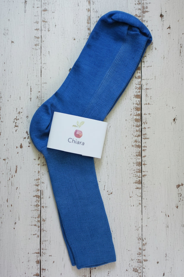 Blue sock with a white label on a wooden surface