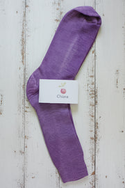 Purple sock with a brand label on a wooden surface
