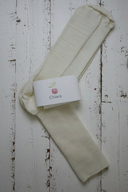 Off white wool socks with a 'Chiara' branded label on a light wooden floor.