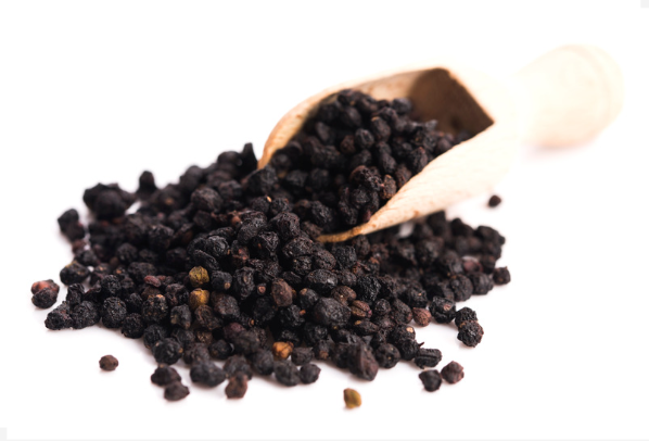 Elderberries dried on a wooden spoon