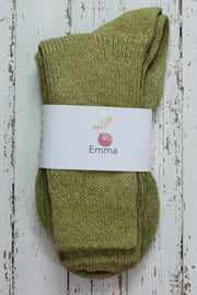 Pair of green socks with a white label on a wooden surface