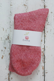 Red sock with a white label on a wooden surface