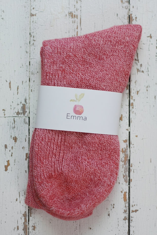 Red sock with a white label on a wooden surface