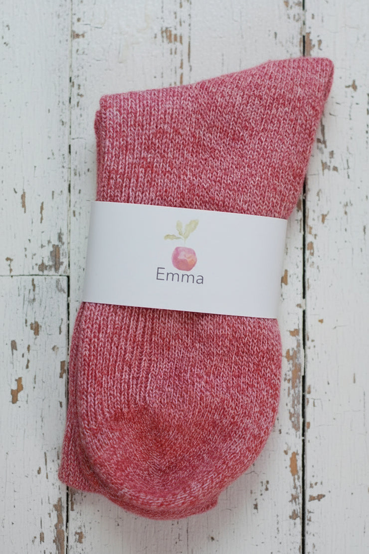 Red sock with a white label on a wooden surface