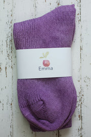 Purple sock with a white label on a wooden surface
