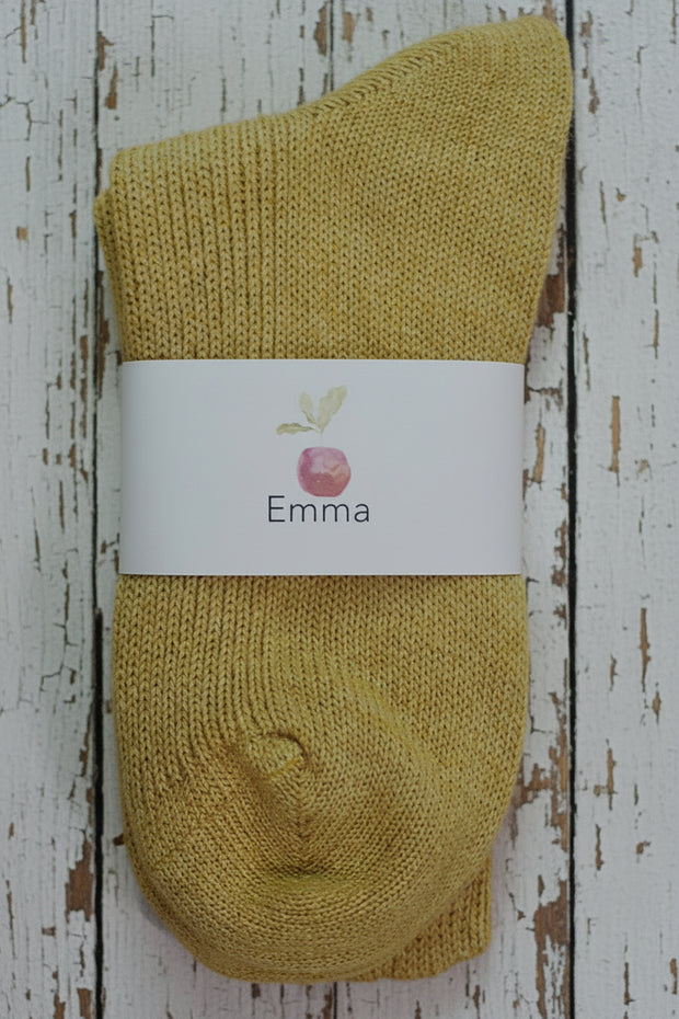 Yellow sock with a white label on a wooden surface