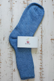 Blue sock with a white label on a wooden surface