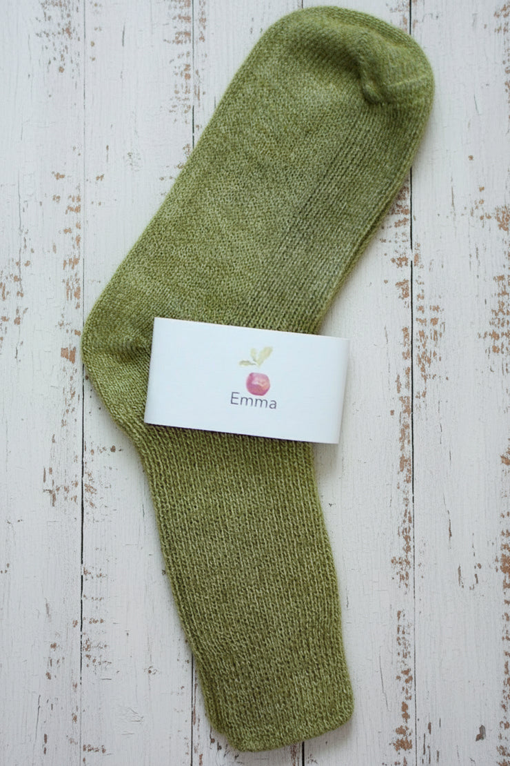 Green sock with a white label on a wooden surface