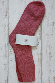 Red sock with a white label on a wooden surface