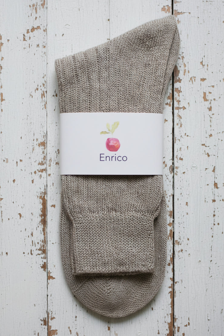 Gray sock with a white label on a wooden surface