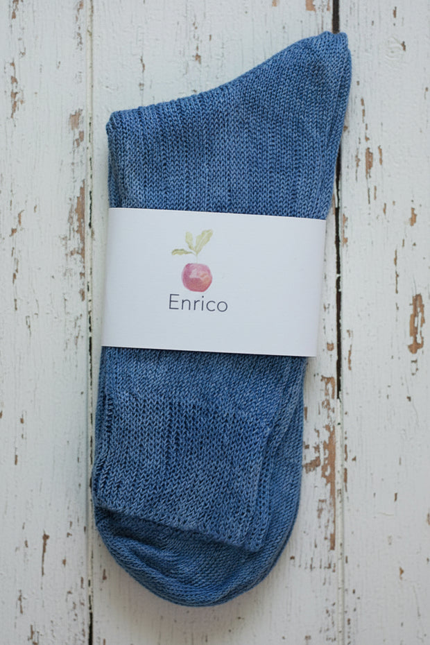 Blue sock with Enrico label on a wooden surface