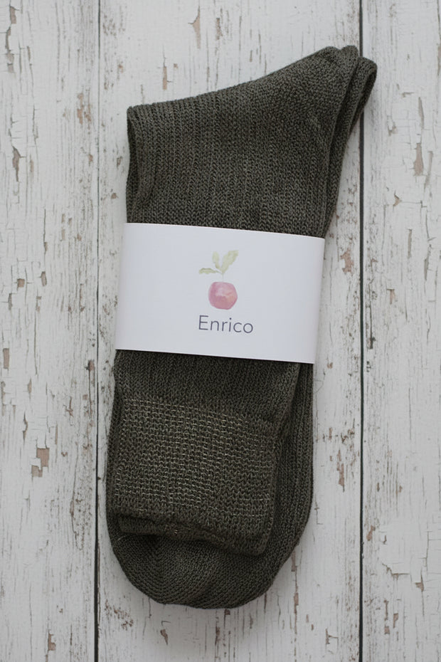 Pair of brown socks with a white label on a wooden surface