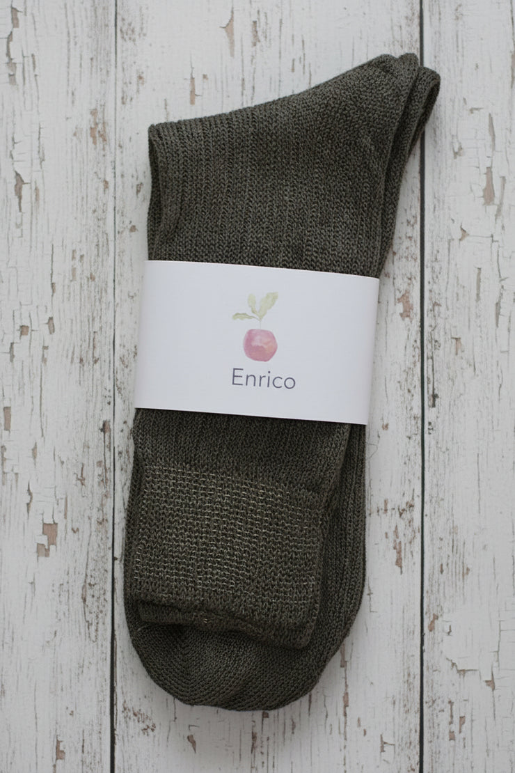 Pair of brown socks with a white label on a wooden surface