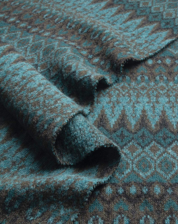 Close-up of textured fabric with a patterned design in teal and brown.