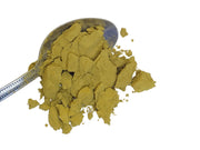 Yellow barberry root powder on a silver spoon on a white background