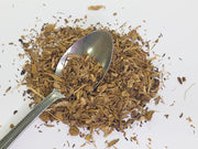 cut yellow brown dock root with a spoon on a white background