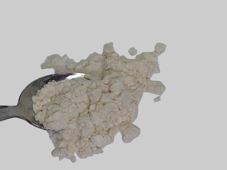 Spoonful of beige oak gall  powder on a white background