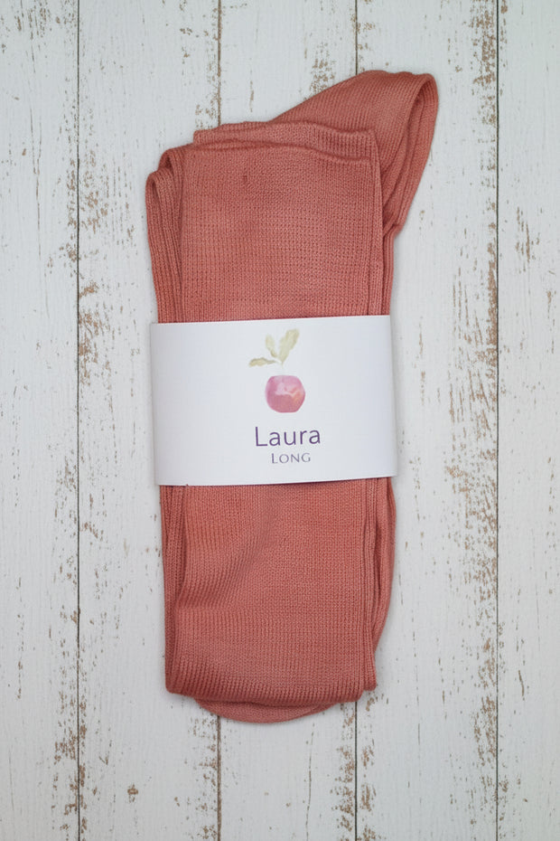 Pair of pink socks with a label on a wooden surface