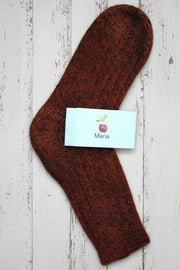 orange wool maria sock with a white label on a wooden surface