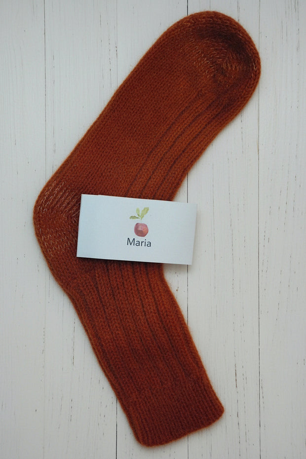orange sock with a white label on a light wooden surface