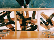 Abstract art piece with geometric shapes on a wooden frame.