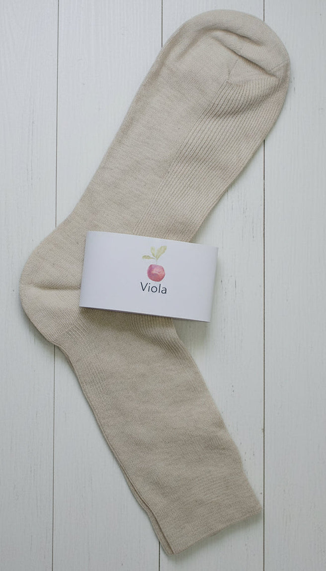 White sock on white timber background with white label and apple symbol with the name viola