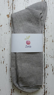 Gray sock with a white label on a wooden surface