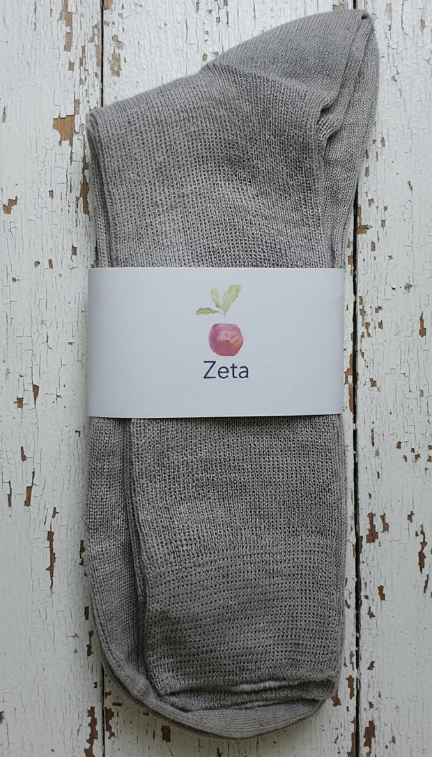 Gray sock with a white label on a wooden surface