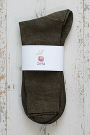 Brown sock with a white label on a wooden surface