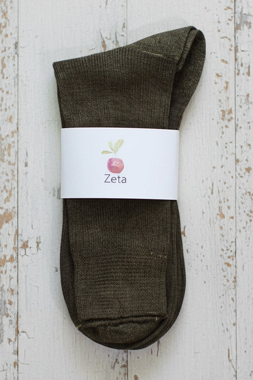 Brown sock with a white label on a wooden surface