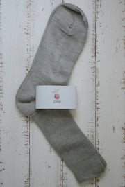 Gray sock with a Zeta label on a wooden surface