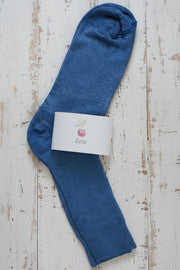 Blue unfolded zeta sock with a white label on a wooden surface