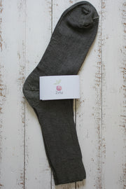 Brown unfolded sock with a white label on a wooden surface