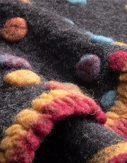 Close-up of a textured fabric with colorful  dots details on a dark background