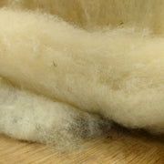 Close-up of raw wool fibers on a wooden surface