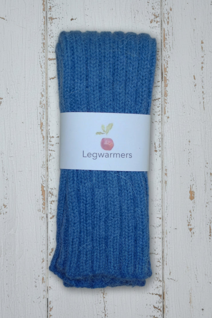 Blue legwarmers with a white label on a white wooden surface