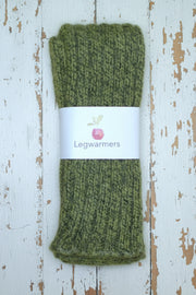 Mottled Green knitted legwarmers with a label on a white wooden surface