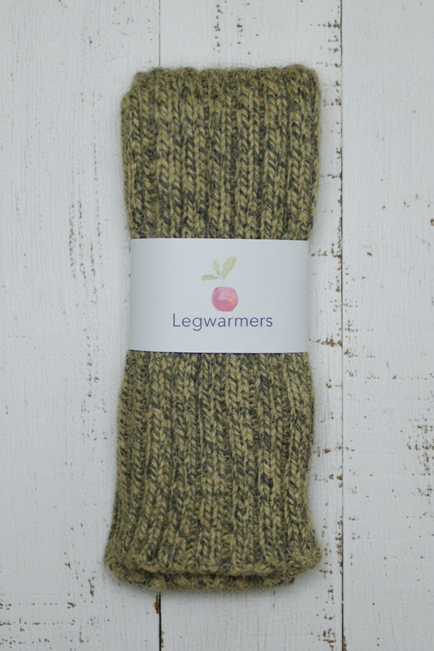mustard yellow Green mottled knitted legwarmers with a label on a white wooden surface