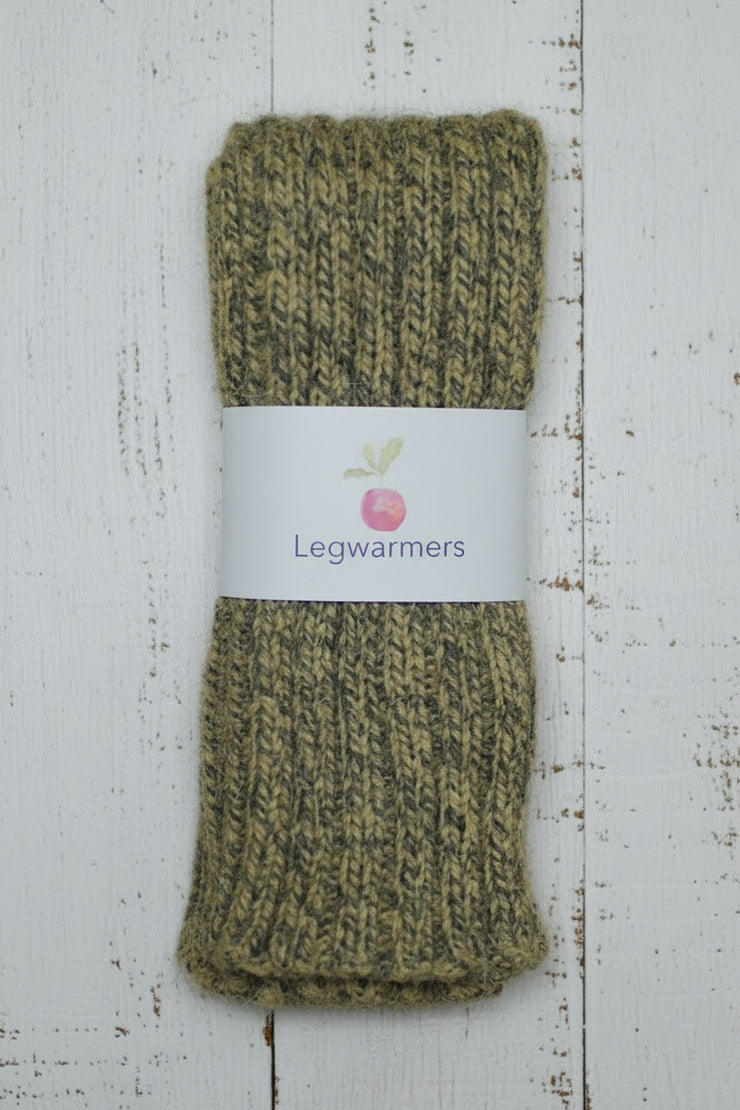 mustard yellow Green mottled knitted legwarmers with a label on a white wooden surface