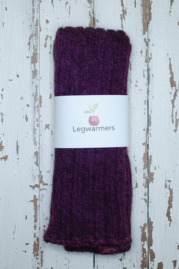 Purple leg warmers with a visible brand label on a wooden surface