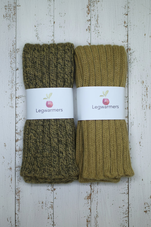Two pairs of mustard legwarmers on a wooden surface with 'Legwarmers' labels.