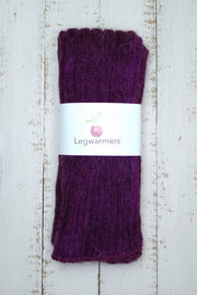 Purple leg warmers with a white label on a wooden surface