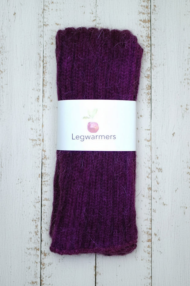 Purple leg warmers with a white label on a wooden surface