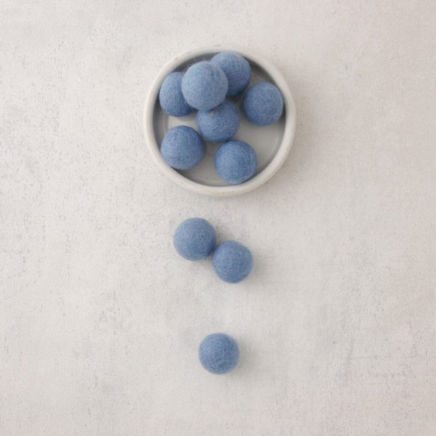 blue felt beads in bowl